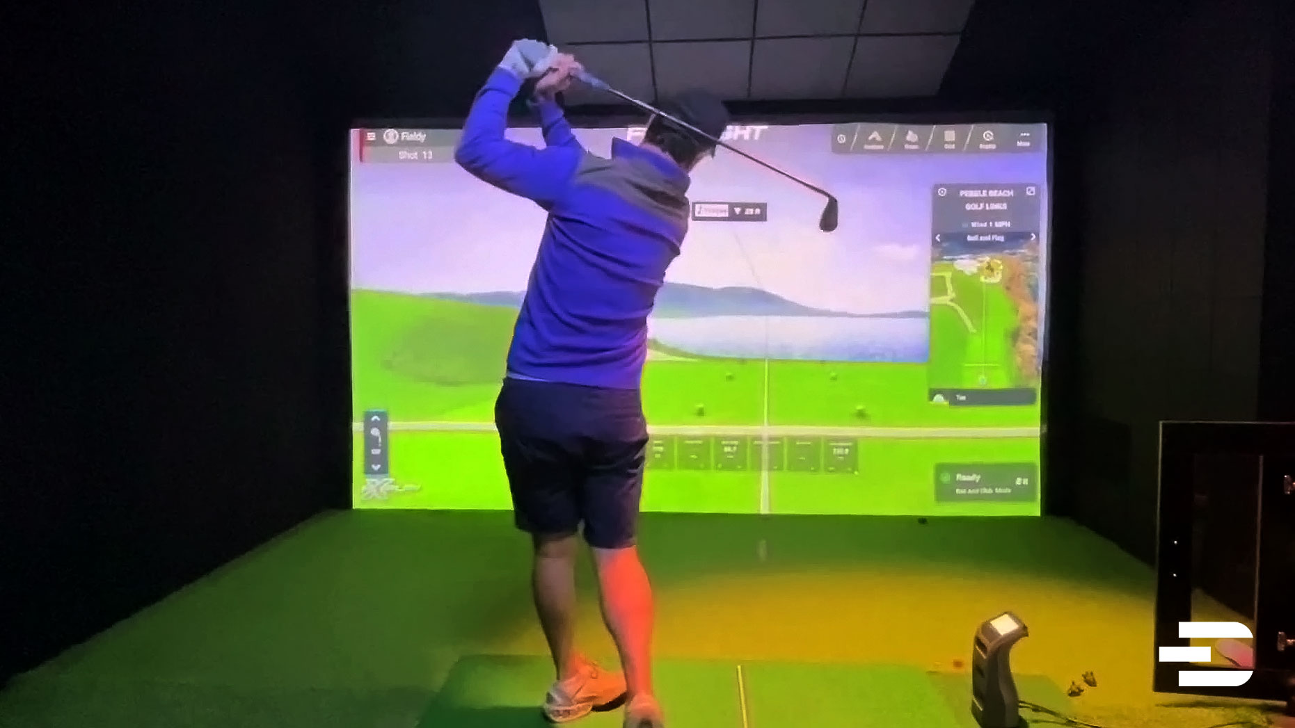 Golfer hitting into indoor simulator screen using GC3 and FSX gameplay at Pebble Beach