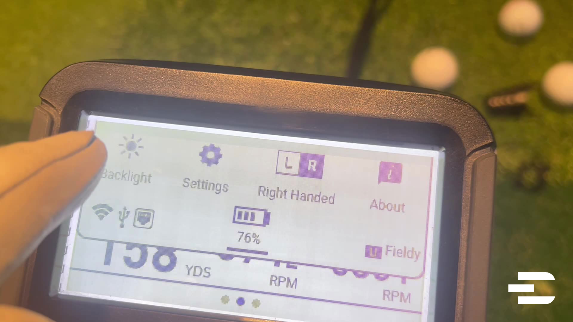 Close-up of the Bushnell Launch Pro screen showing 76% battery, right-handed mode, and settings menu.